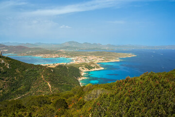 Obraz premium View of Golfo Aranci at Sardinia north, clear blue water beaches on both sides, from higher hill near