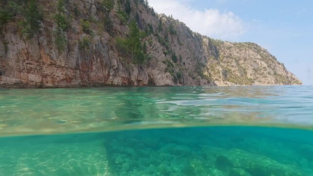 Landscape and sea at Butterfly Valley near Oludeniz, split video half underwater