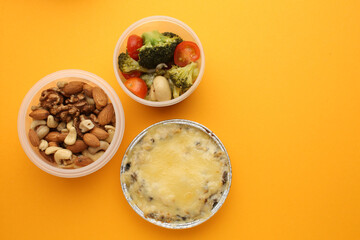 Healthy diet. Different meals in containers and products on yellow background, flat lay. Diet and calorie counting Space for text