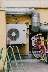 air conditioner on facade of building in southern hot country next to bicycle parking lot. facade...