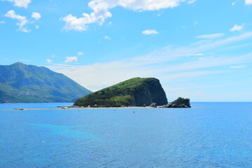 Fototapeta premium Budva, Montenegro - May 04, 2024 : The Old Town Fortress in Budva. A stone wall on the shore of the Adriatic Sea in Montenegro. Horizontal. On a hot, sunny, spring afternoon. 