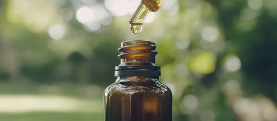 Amber bottle, essential oil drops falling.