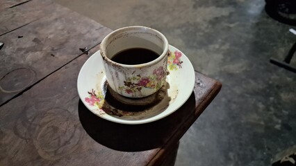 Cup of Black Coffee on Rustic Wooden Table: Simple Coffee Mug and Saucer on a Textured Wood Surface, Morning Drink