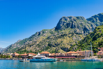 Kotor  Montenegro, May 11, 2024: The Bay of Kotor and boats and the mountainous background. The Adriatic Sea Coast on a sunny, hot, Spring Afternoon.