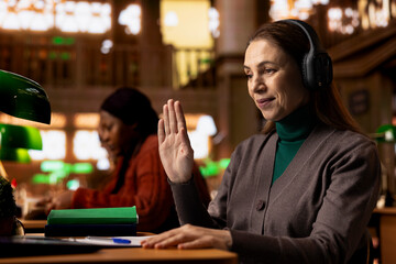 Female student joins a remote video call for an online university course, studying digital materials and preparing a college project in a calm study space with books and academic focus.