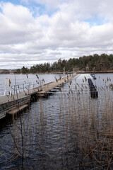 Obraz premium Empty marina for tourist and boating season to start. Early spring view of mooring. landscape with row of free piers on lake. Sunny cloudy day.