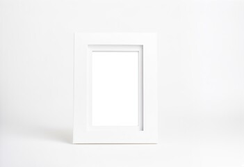 A white picture frame on a white surface.