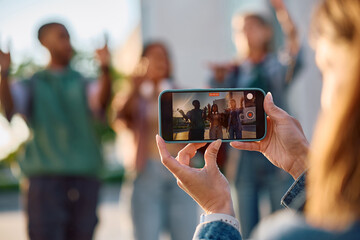 Close up of students recording social media video outdoors.