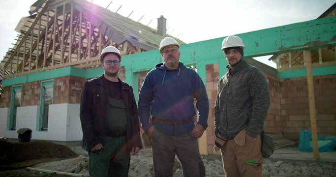 Construction crew posing at building site, group of construction professionals united at project location, teamwork and collaboration in construction industry environment