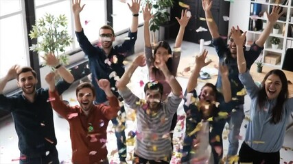 A joyful group of diverse coworkers celebrates a significant achievement in their modern office, throwing colorful confetti while sharing smiles and laughter. The atmosphere is lively and energetic