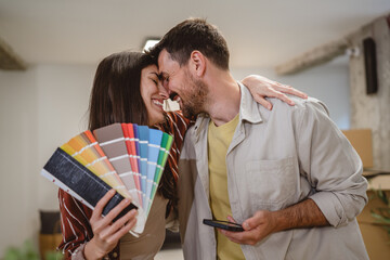 Self portrait of couple hold color palette and choose new wall color