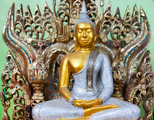 Obraz premium Gilded figure of Buddha on a throne.