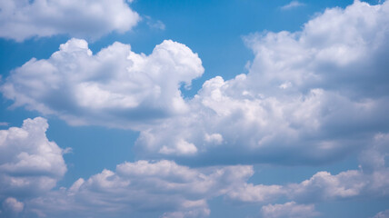 Obraz premium Beautiful fluffy white clouds floating in a vibrant blue sky during a sunny day