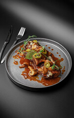 Dark Scene with Plated Meat in Rich Sauce