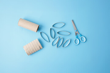 step by step instruction, DIY crafting process, cutting upcycled cardboard tube with blue scissors, creating rings for handmade projects, perfect for sustainability campaigns, education, workshops