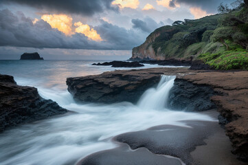 Obraz premium Hidden waterfall in under stormy clouds