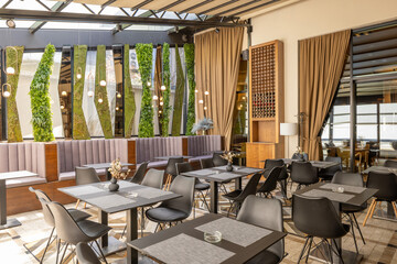 Trendy modern dining space with inviting atmosphere and soft seating and wall decoration