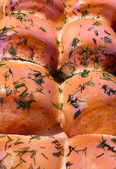 soft bread rolls are freshly baked and lined up, garnished with fragrant herbs, in cozy kitchen...