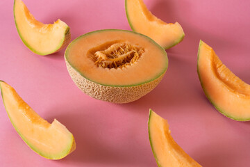Sliced cantaloupe arranged on a pink background: refreshing summer fruit