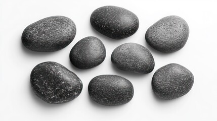 Smooth, grey stones arranged on a white surface