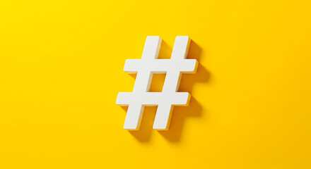 Obraz premium A white hashtag symbol casting a shadow on a bright yellow background in a simple studio shot