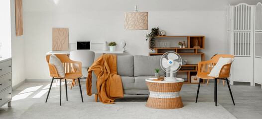 Interior of stylish living room with modern electric fan on coffee table