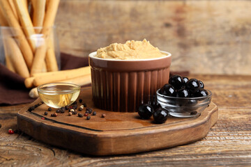 Bowl with tasty hummus on wooden background