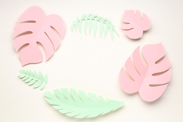 Frame made of paper tropical leaves on beige background