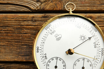 Aneroid barometer on brown wooden background