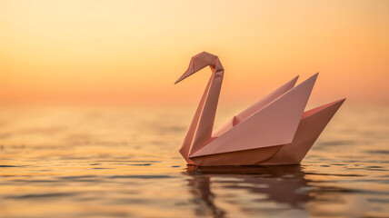 A minimalist photograph of a pale pink origami swan floating on rippling water during sunset.