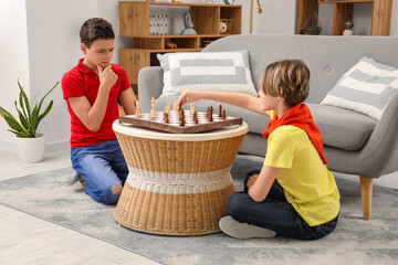 Happy brothers playing chess at home