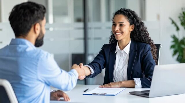 Female hr bank manager, financial advisor handshaking recruit, greeting client. Hiring at job interview, partnership concept. Handshake of happy young business woman and business man at office meeting