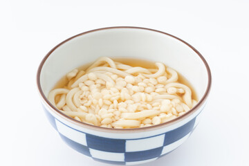 どんぶりに入った天かすを載せたうどん