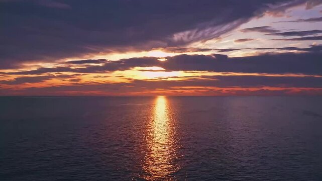 Ocean sunset with dramatic clouds and warm reflection on the water, evoking peace and awe.