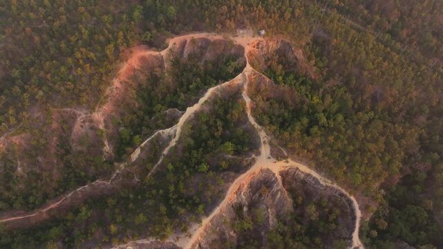 Sunrise over narrow ridge lines and forested valley in Pai Canyon, Thailand Aerial drone video