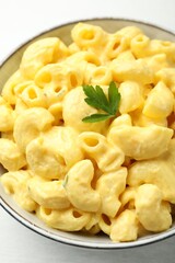 Delicious pasta with cheese sauce in bowl on table, closeup