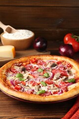 Tasty pizza with smoked sausages and ingredients on wooden table, closeup