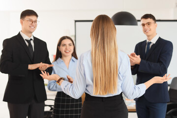 Fototapeta premium Business people clapping woman after negotiations in conference hall, back view