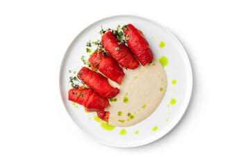 Baked roasted red pepper with cheese sauce on plate isolated on white background. Healthy food, close up, top view