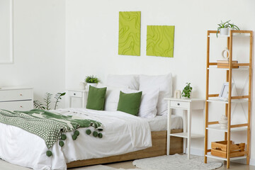 Obraz premium Interior of stylish bedroom with cozy bed, bedside table and beautiful paintings