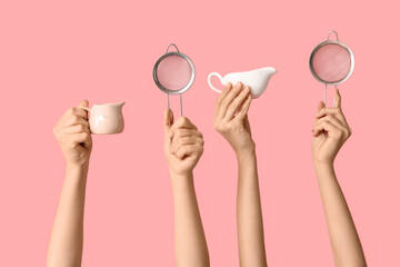 Female hands holding sieves with milk jugs on pink background
