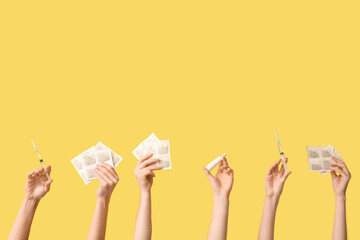 Female hands with mustard plasters, nasal spray and syringes on yellow background