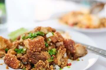 A plate of crispy pork belly stir fried with holy basil (kra pao moo grob), white rice and a fried egg at a street food stall at Soi 20 - Silom, Bangkok, Thailand