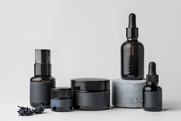 Black cosmetic bottles and jars on grey stone