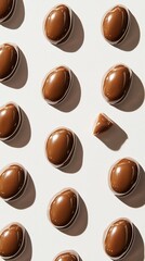 Fototapeta premium A grid of glossy brown chocolates, one uniquely broken