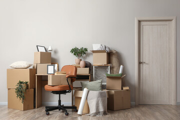 Workplace with cardboard boxes near light wall in room on moving day