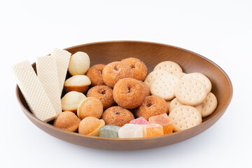 白背景に木製のお皿に載せた甘いお菓子の盛り合わせ