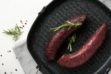 Grill pan with tasty blood sausage on white background, closeup