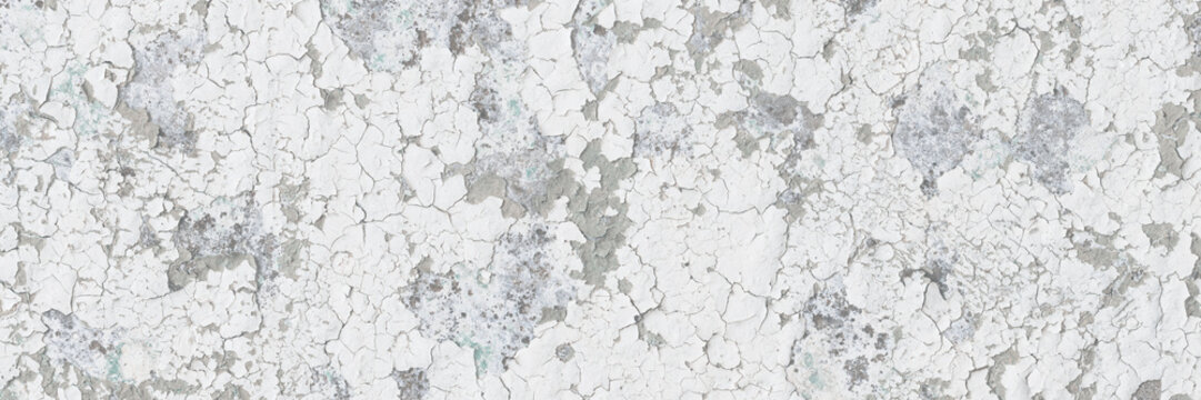 Peeling paint on the wall. Old concrete wall with cracked flaking paint. Weathered rough painted surface with patterns of cracks and peeling. Grunge texture for background and design. High resolution.