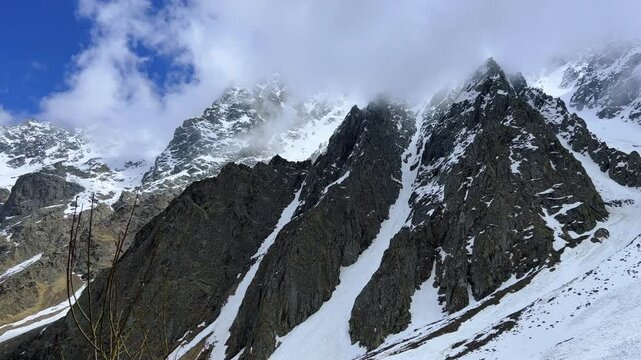 The Fairy Tale Gorge in Ossetia. Snowy mountains in the clouds. Mountain view near the Fairy Tale glacier, which is located in the Tsey Gorge in the North Caucasus. North Ossetia-Alania, Russia. 4К